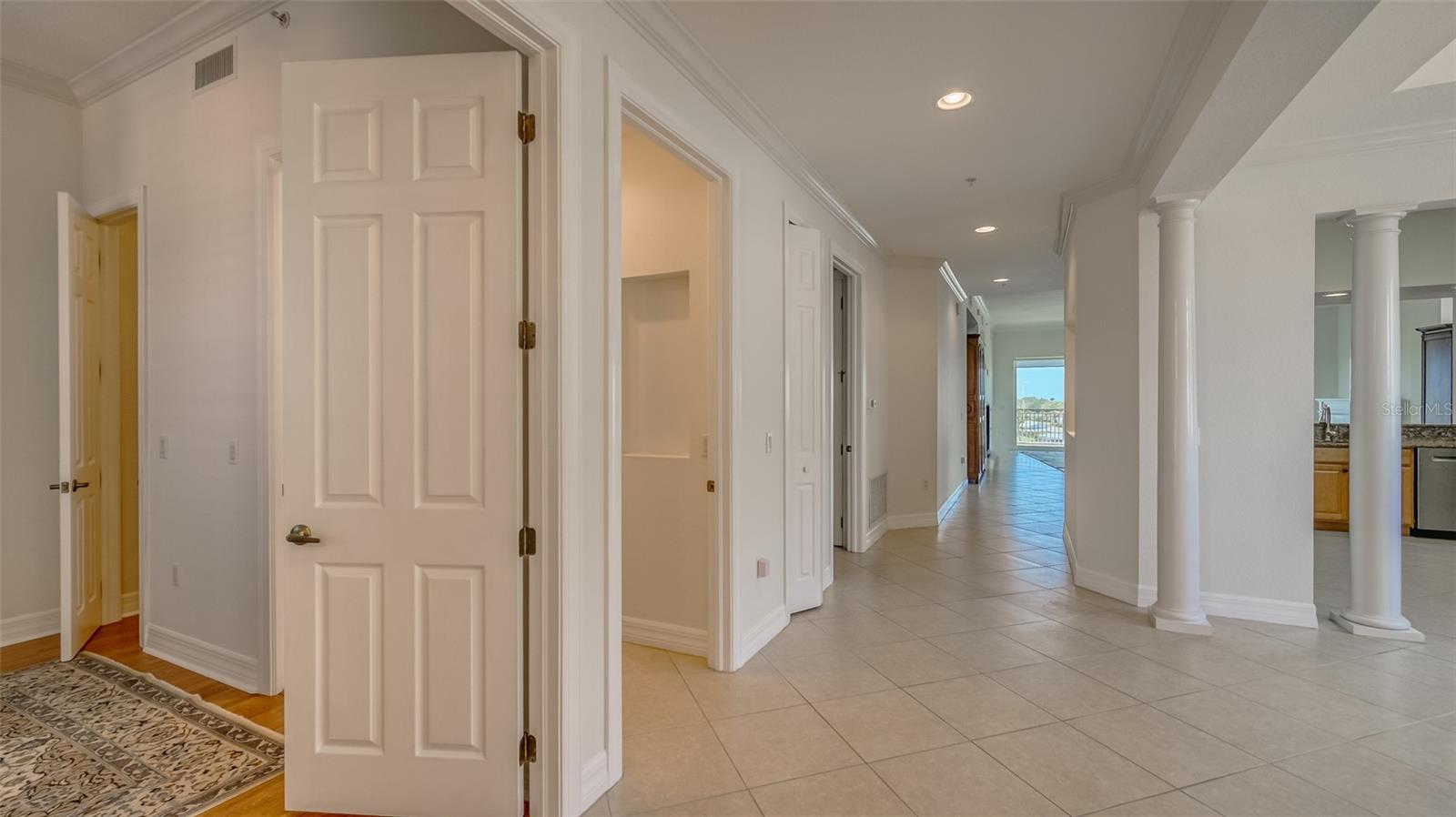 View from entry hallway with guest room, ensuite bath, broom closet, laundry room on left and dining area and kitchen to right.