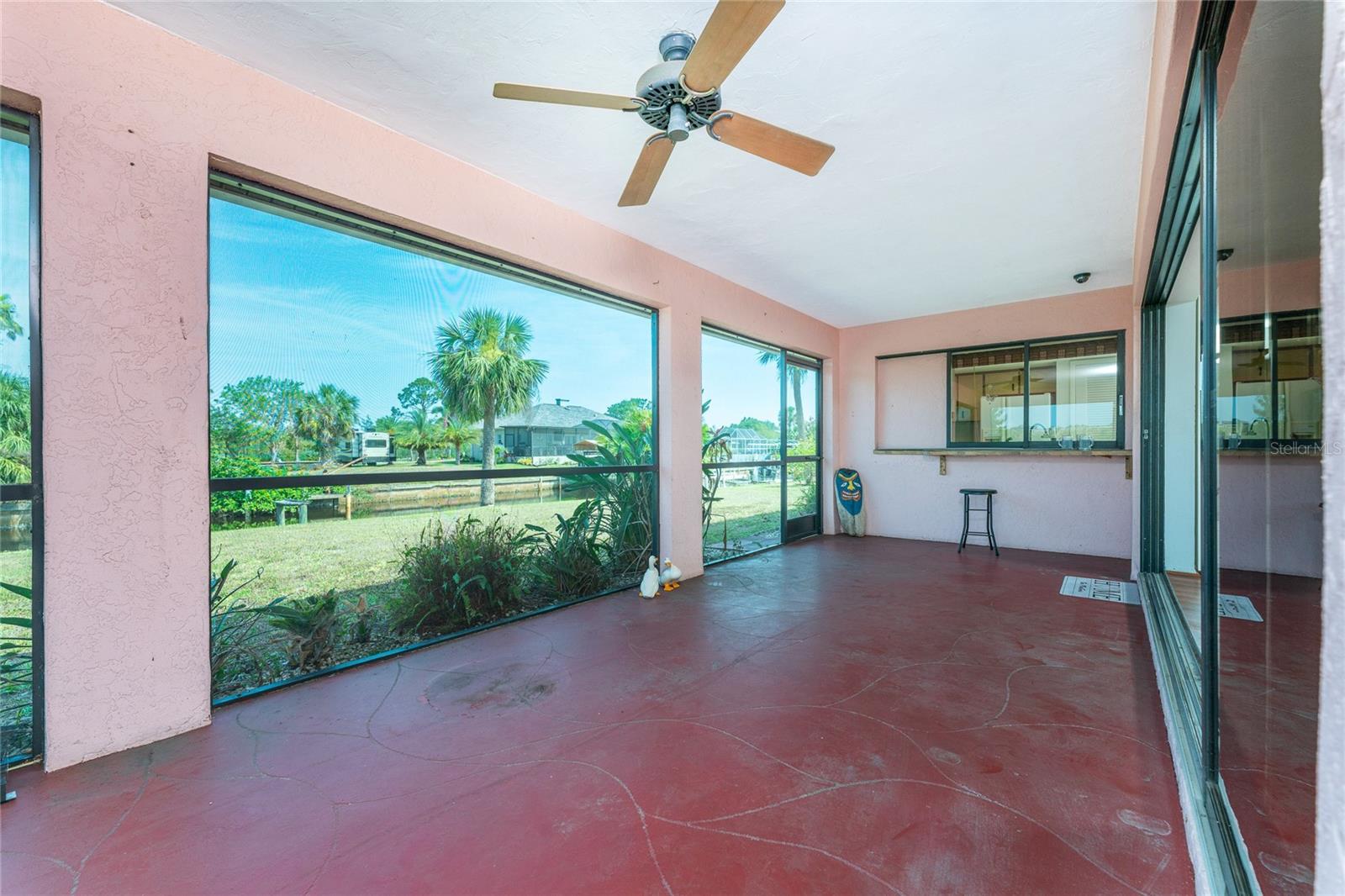Lanai looking to rear yard & pocketing sliding window to Kitchen.