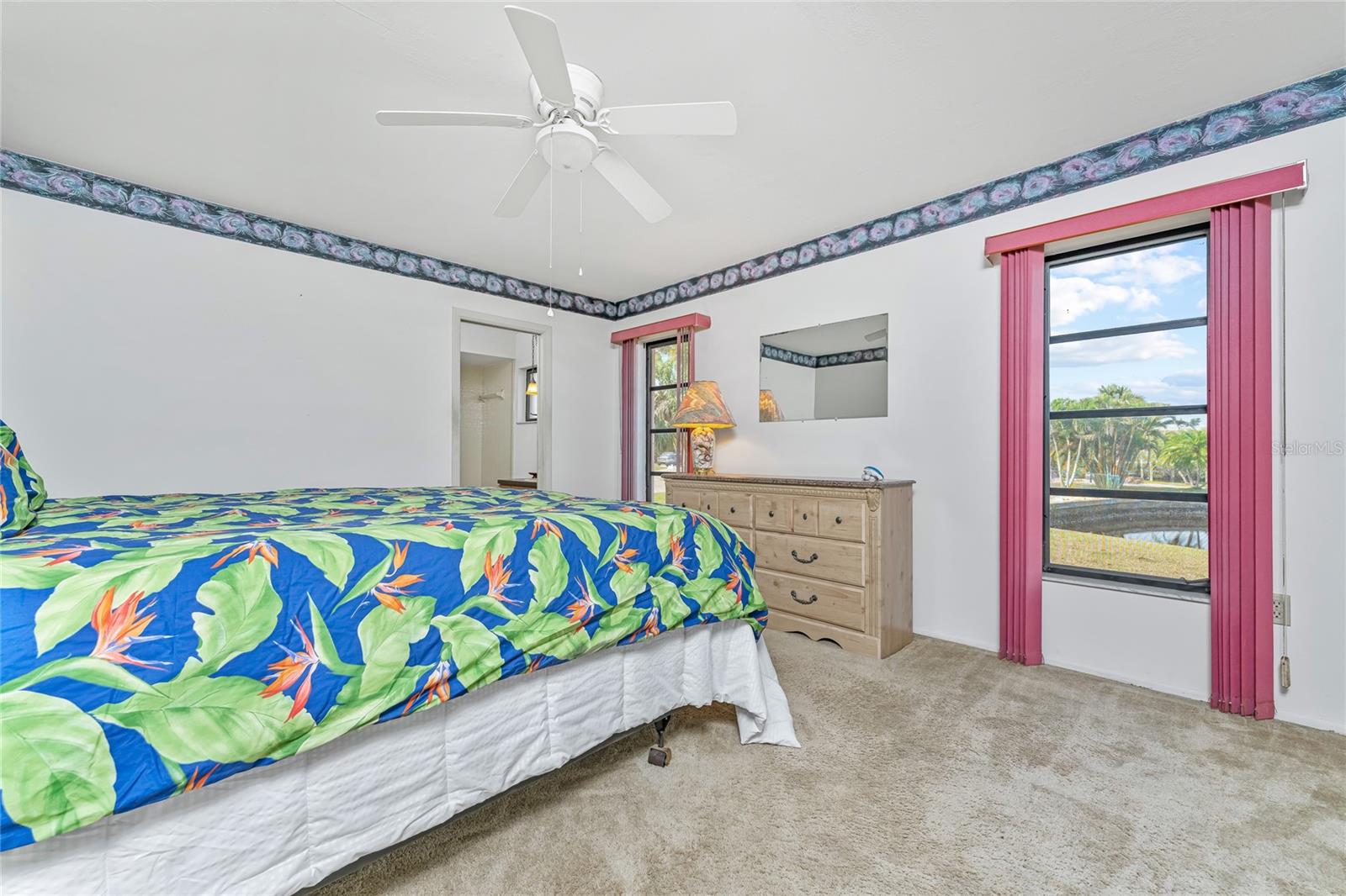 Owner Suite with waterfront view to the west & ensuite bath & closet to the left.