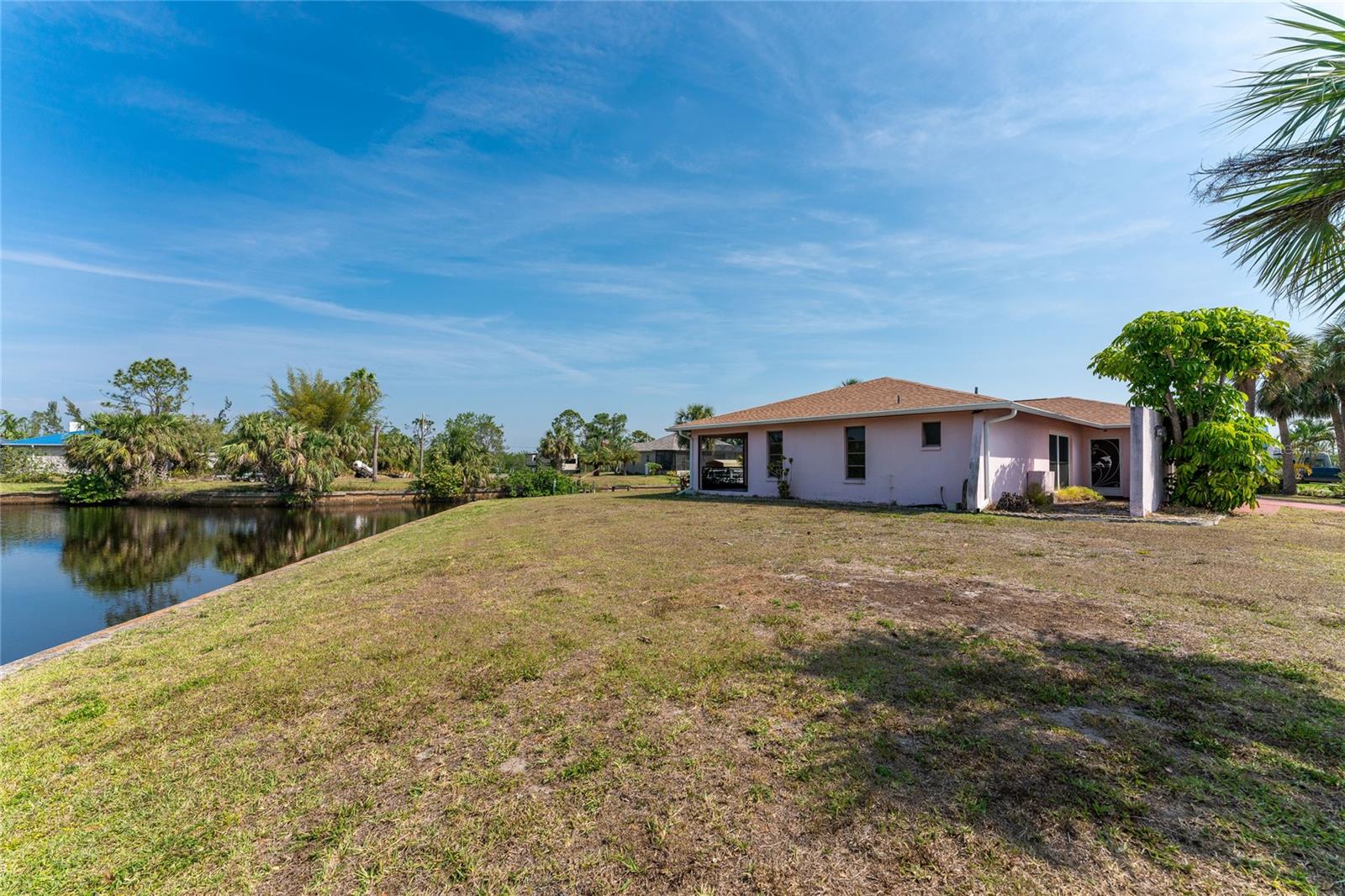 Left side of home is owner suite wing with large side yard to the canal.