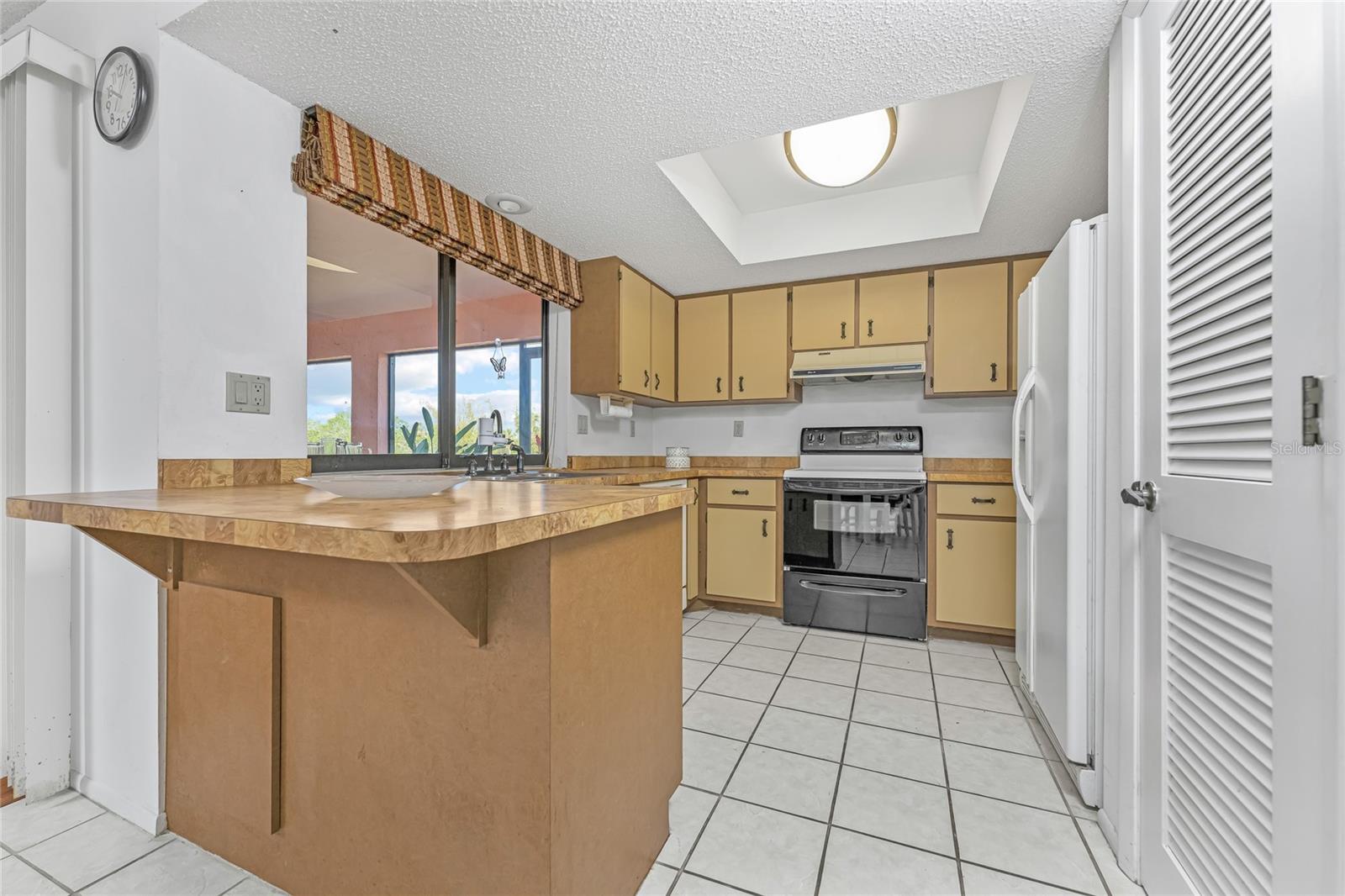 Kitchen breakfast bar with pantry closet louvered doors.