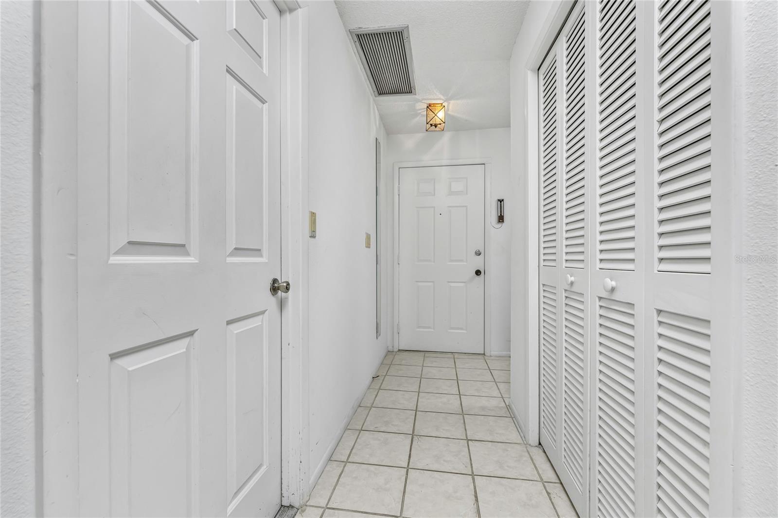 Entry hallway with door to garage on the left & storage closet on the right.