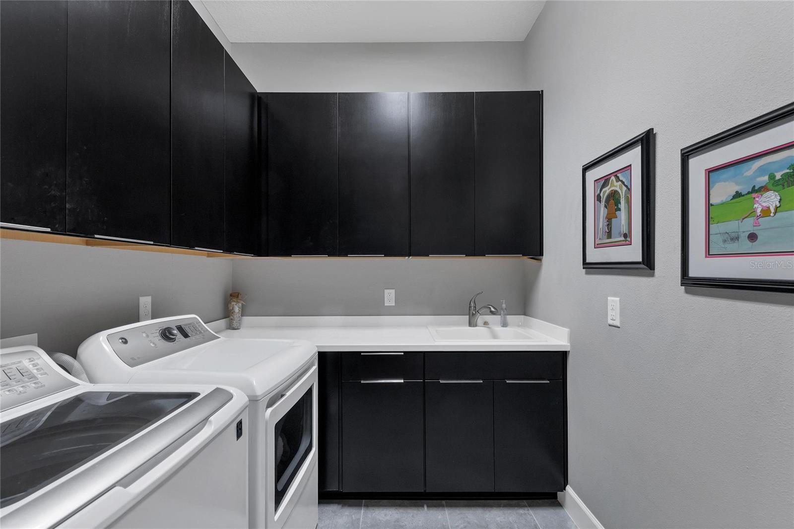 Separate Laundry Room Has Great Cabinet Space For Storage And Is Adjancent To the 3 Car Climate Controlled Garage