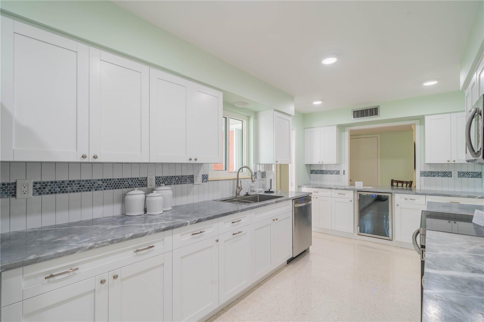 DESIGNER TILE BACK SPLASH WITH UPGRADED SS SLIDE SINK AND FAUCET. BUILT IN BEVERAGE COOLER