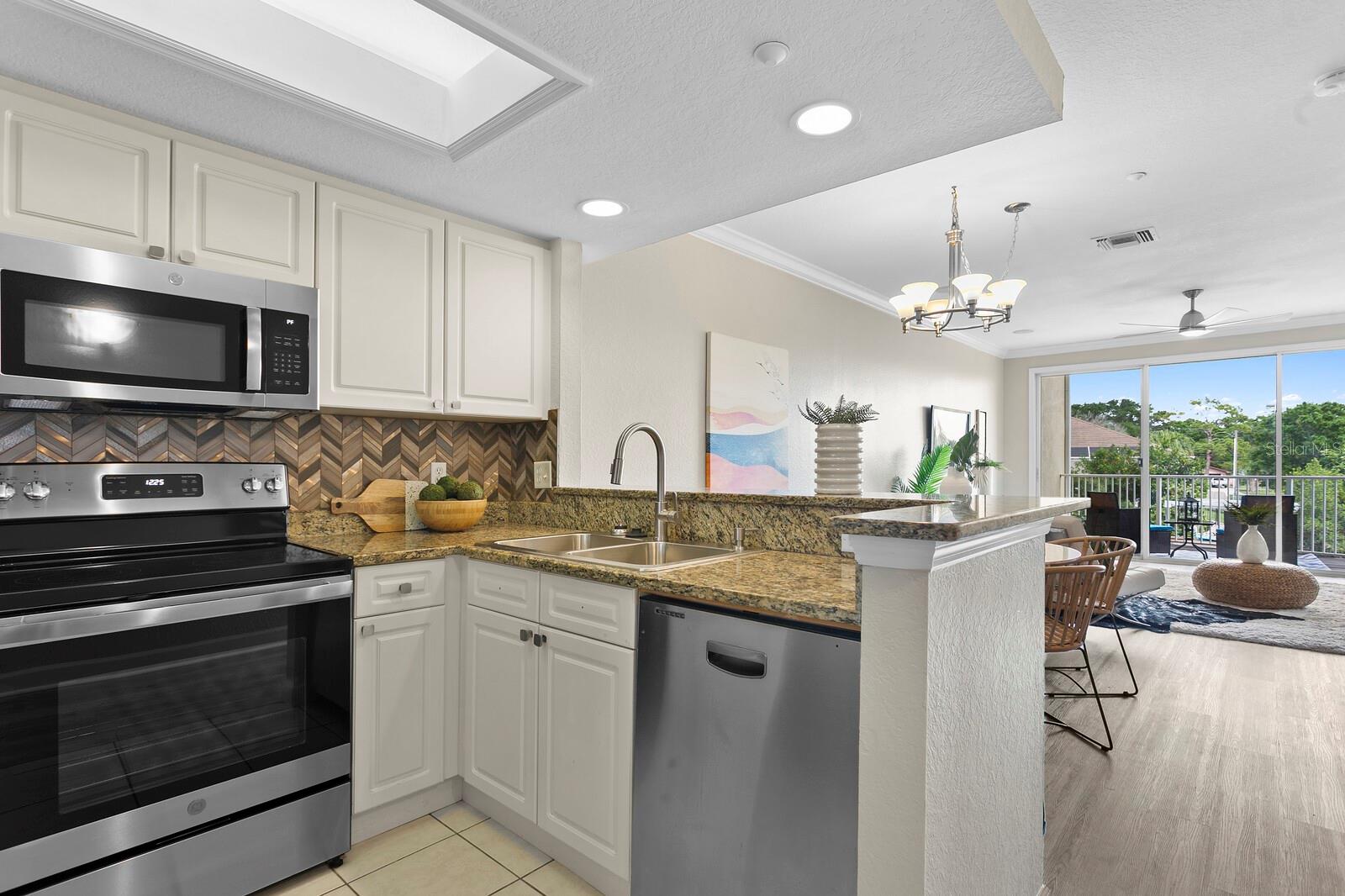 lovely, open kitchen overlooking living area and outdoor living beyond