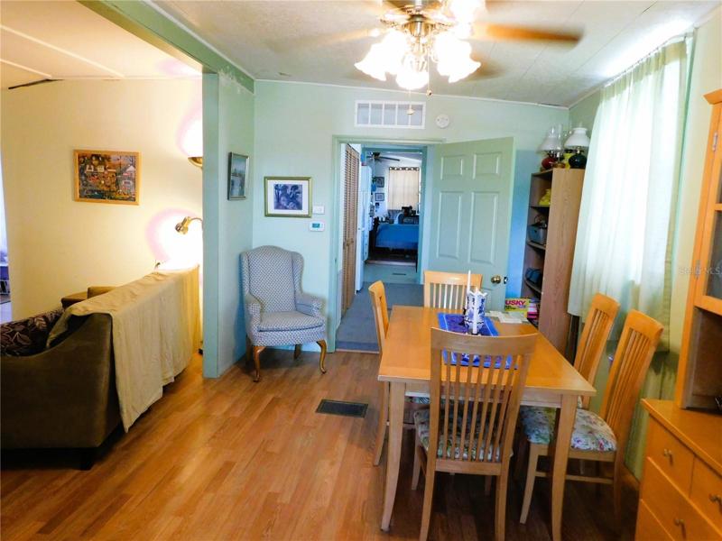 Dining room with laminate flooring and ceiling fan.