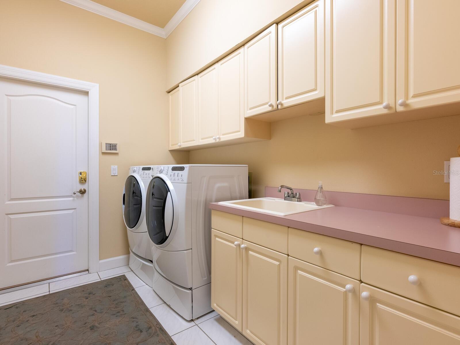Large laundry room with utility sink and plenty of storage.
