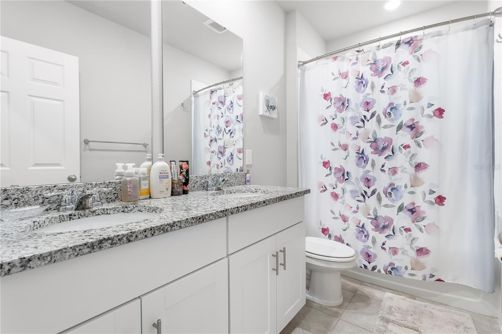 Guest bathroom with dual sinks.