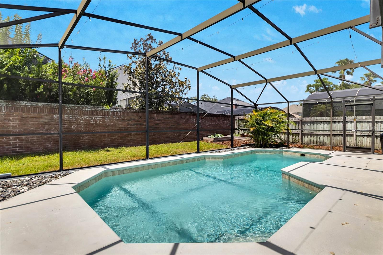 Screened salt water pool and veggie planters in backyard!