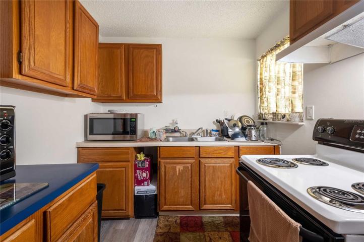 Living room has laminate flooring, Drywall, ceiling fan, open floor plan.