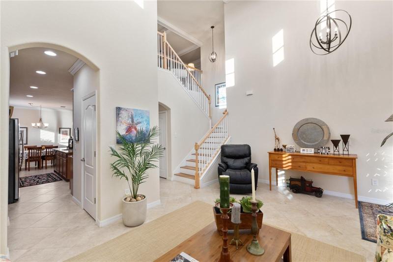 Main entryway and Family room with access to the second floor, the kitchen, and living room.