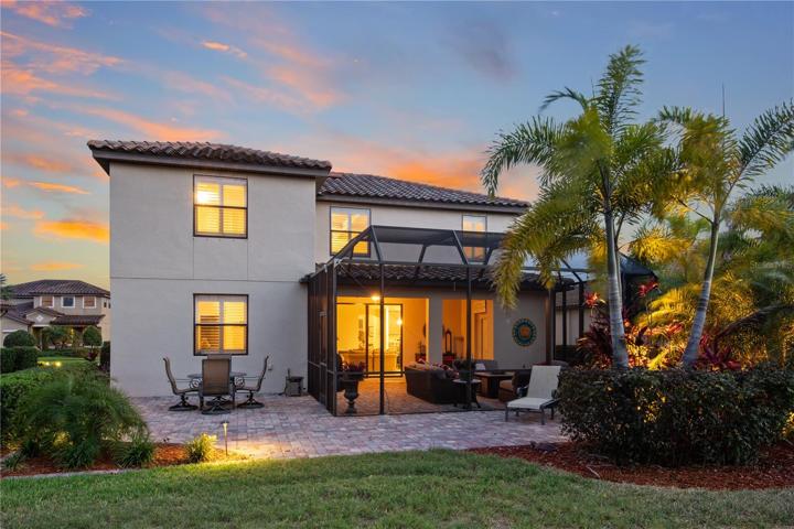 Rear view of home and the Additional extended exposed paver lanai with golf course views
