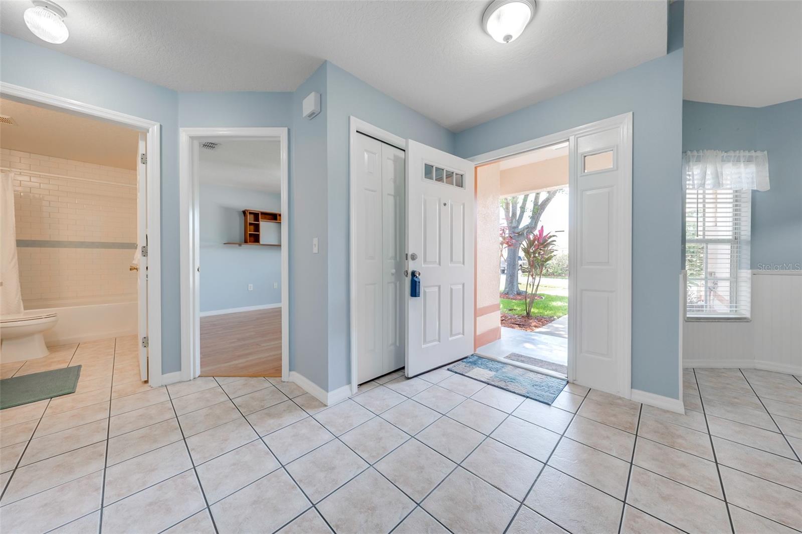 A look back at entry/foyer from inside. Coat closet behind front door. Guest bedroom in the middle and guest bath on left. Kitchen on right.