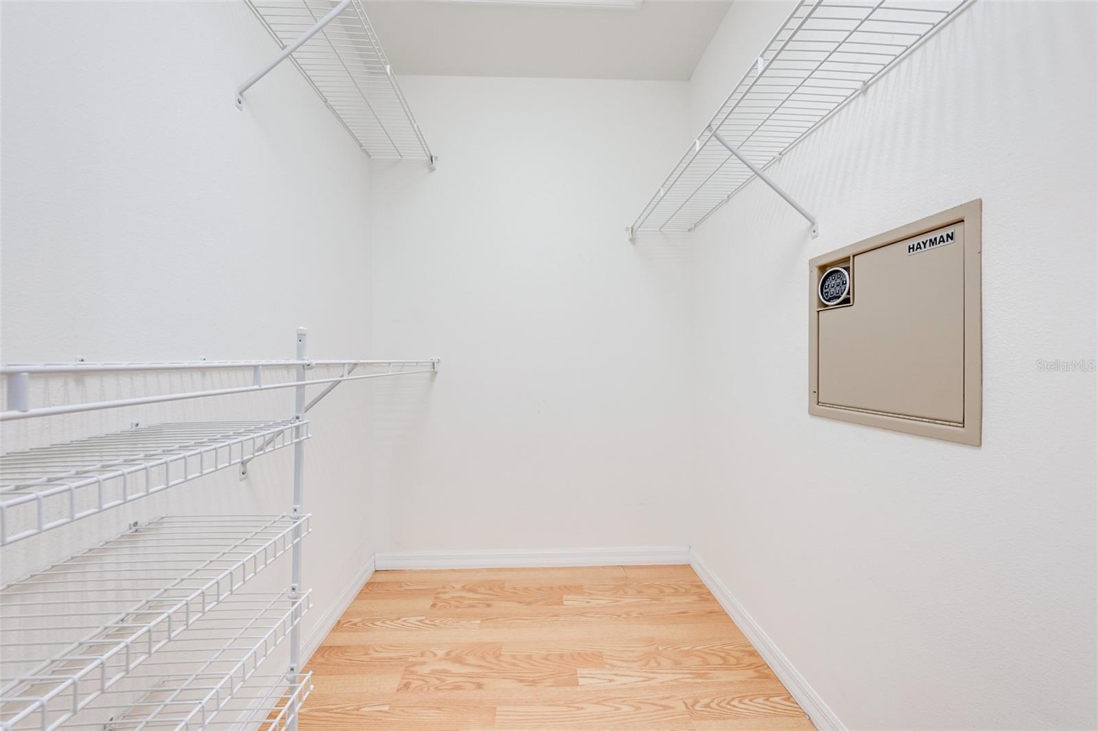 Master's walk in closet with convenient wall safe.