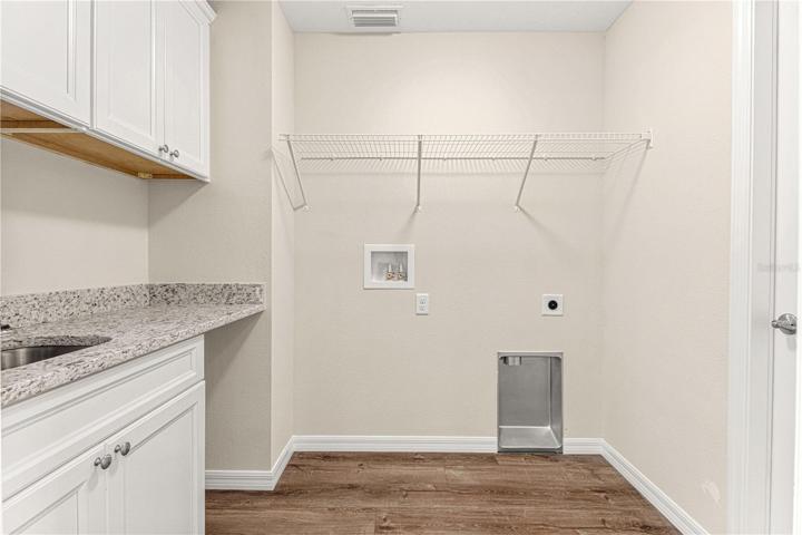 LAUNDRY ROOM WITH CABINETS AND SHELVING PLUS A GRANITE FOLDING BAR