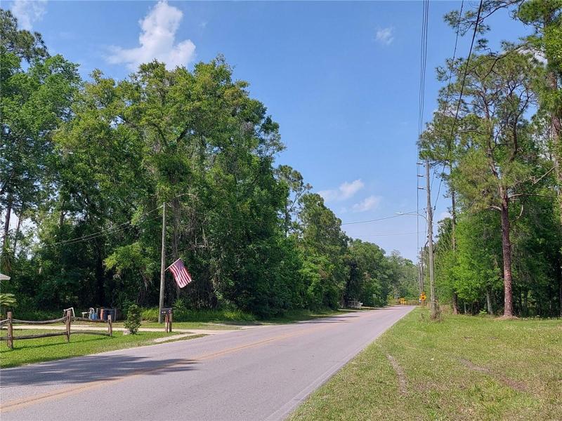 Located on Lake Dr., has a paved road and a house across the street