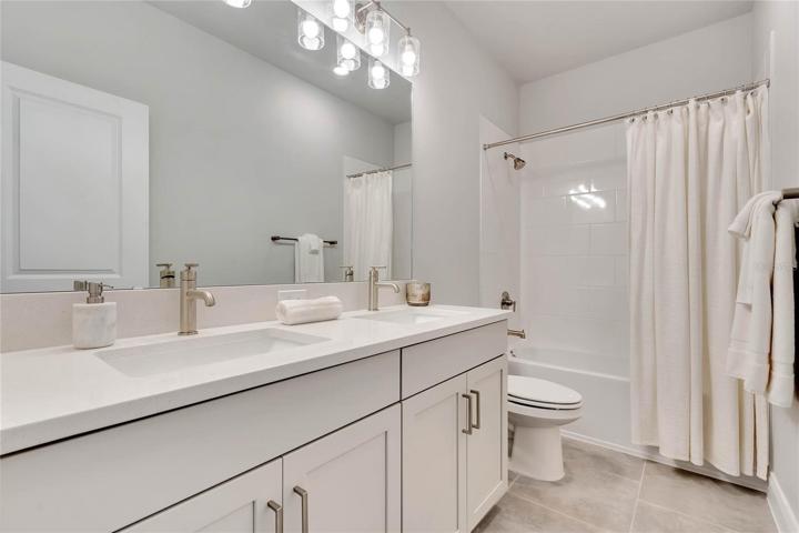 The upstairs bathroom has double sinks and a shower/tub combination