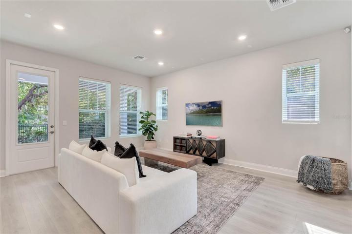 The downstairs living area has many windows and beautiful views of the lush landscaping around the home