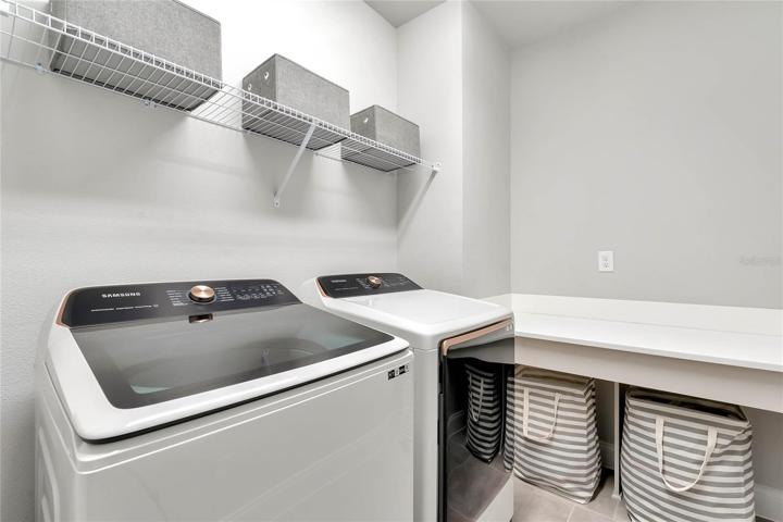 The walk in laundry room comes complete with washer/dryer and folding station