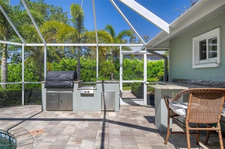 Built in outdoor kitchen with grills, fridge and bar
