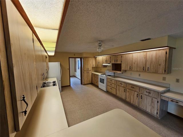 Kitchen from breakfast bar showing desk on the end of the cabinets