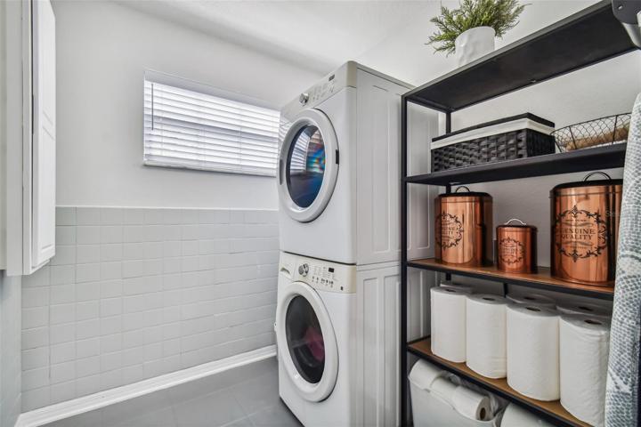 The convenient upstairs laundry room features a stacked front load, high efficiency washer and dryer with plenty of storage space.