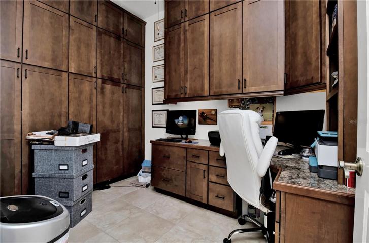 Full wall of custom storage cabinets and desk area