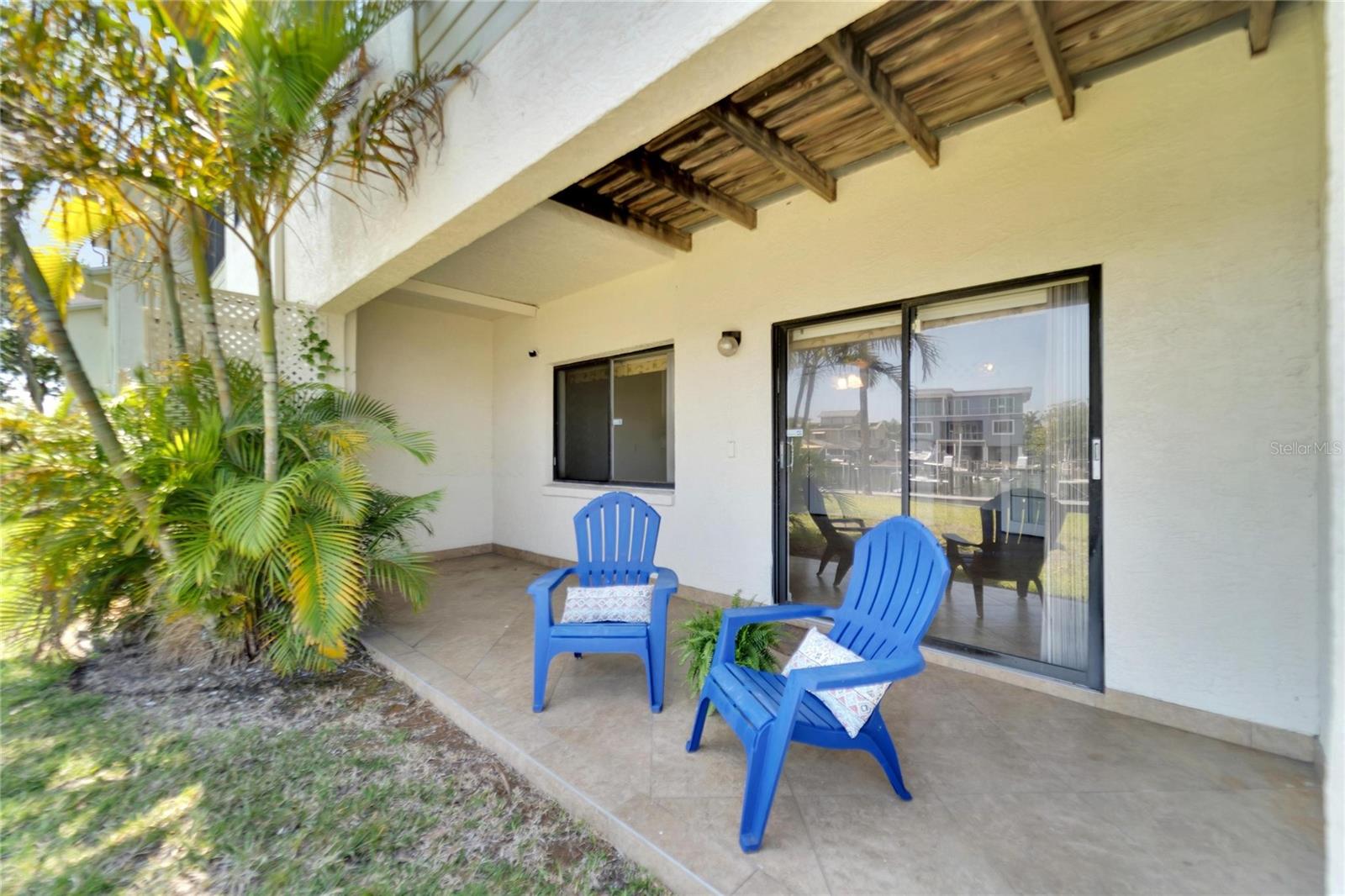 Slider doors leading to private tiled patio overlooking water