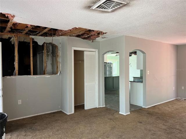 8101 Hixton Dr view from living area toward kitchen and dining. Hole in wall to left goes through to garage.