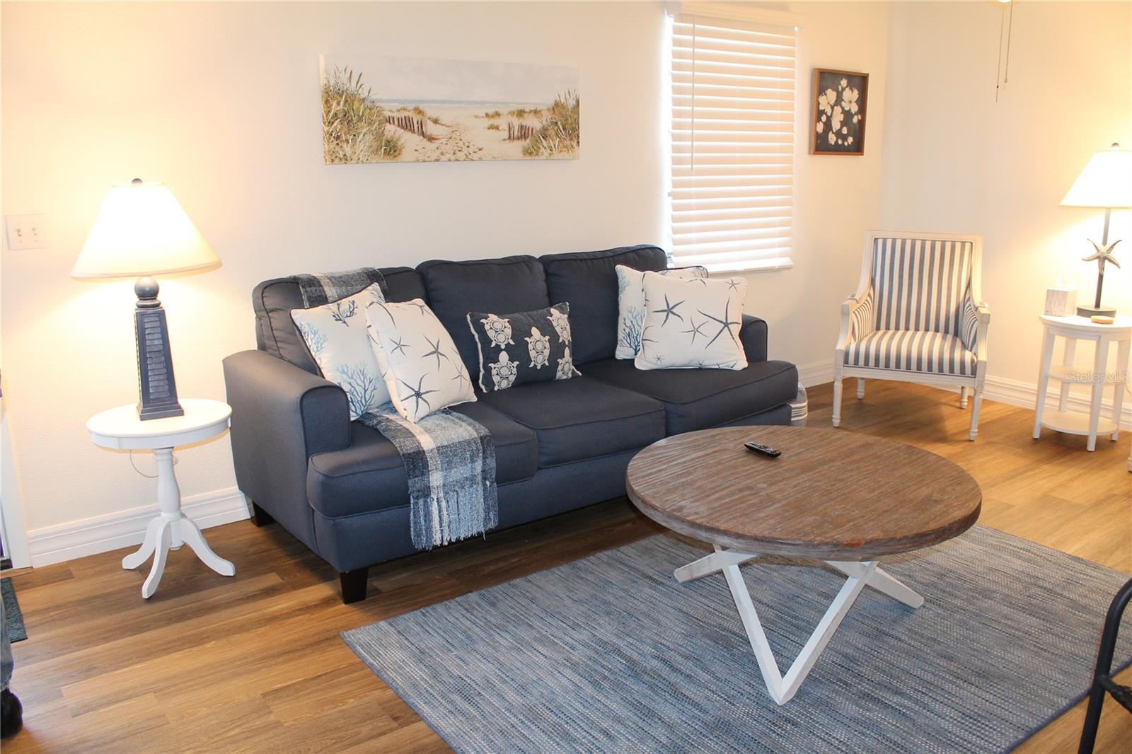 Living Room Area With Couch And Several Single Chairs.