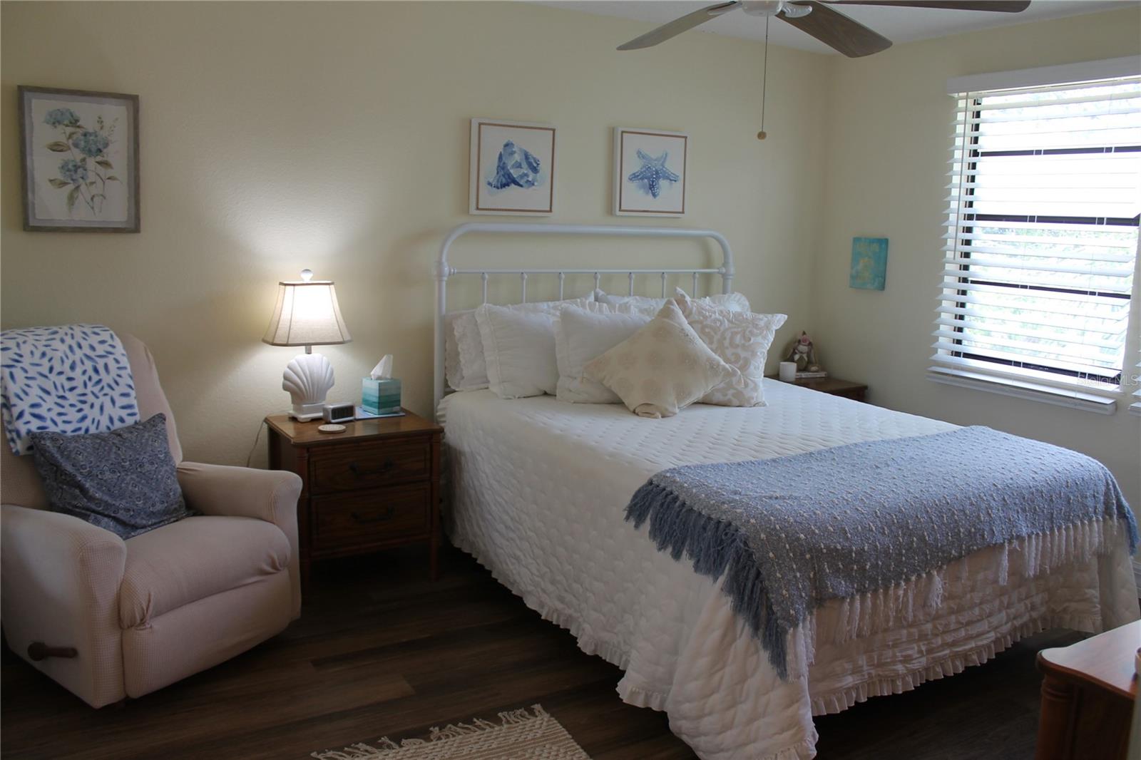 Master Bedroom With Ceiling Fan And Side Lounge Chair.