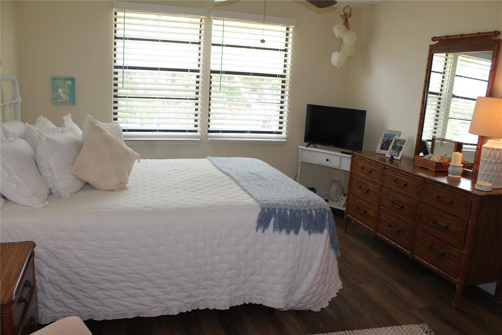 Master Bedroom With Flat Screen TV, End Table And Mirror Dresser.