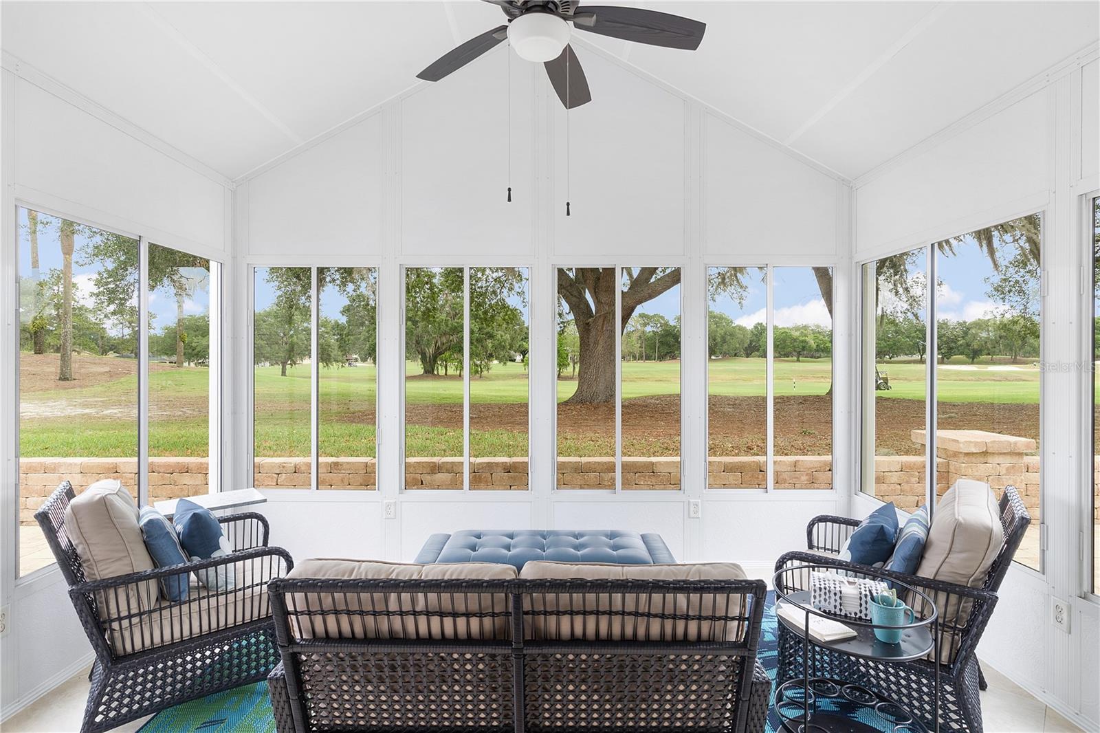 GLASS ENCLOSED LANAI WITH TILE FLOOR.