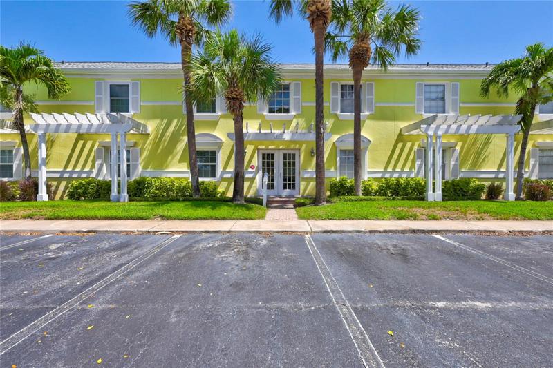 Front of the building such a tropical feel with the warm Yellow Florida sun color and Palm trees.