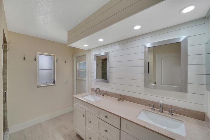 Lanai bath is shared with bedrooms two and three an features custom Kraft Maid cabinets with custom counter top, custom tiled shower and toilet.