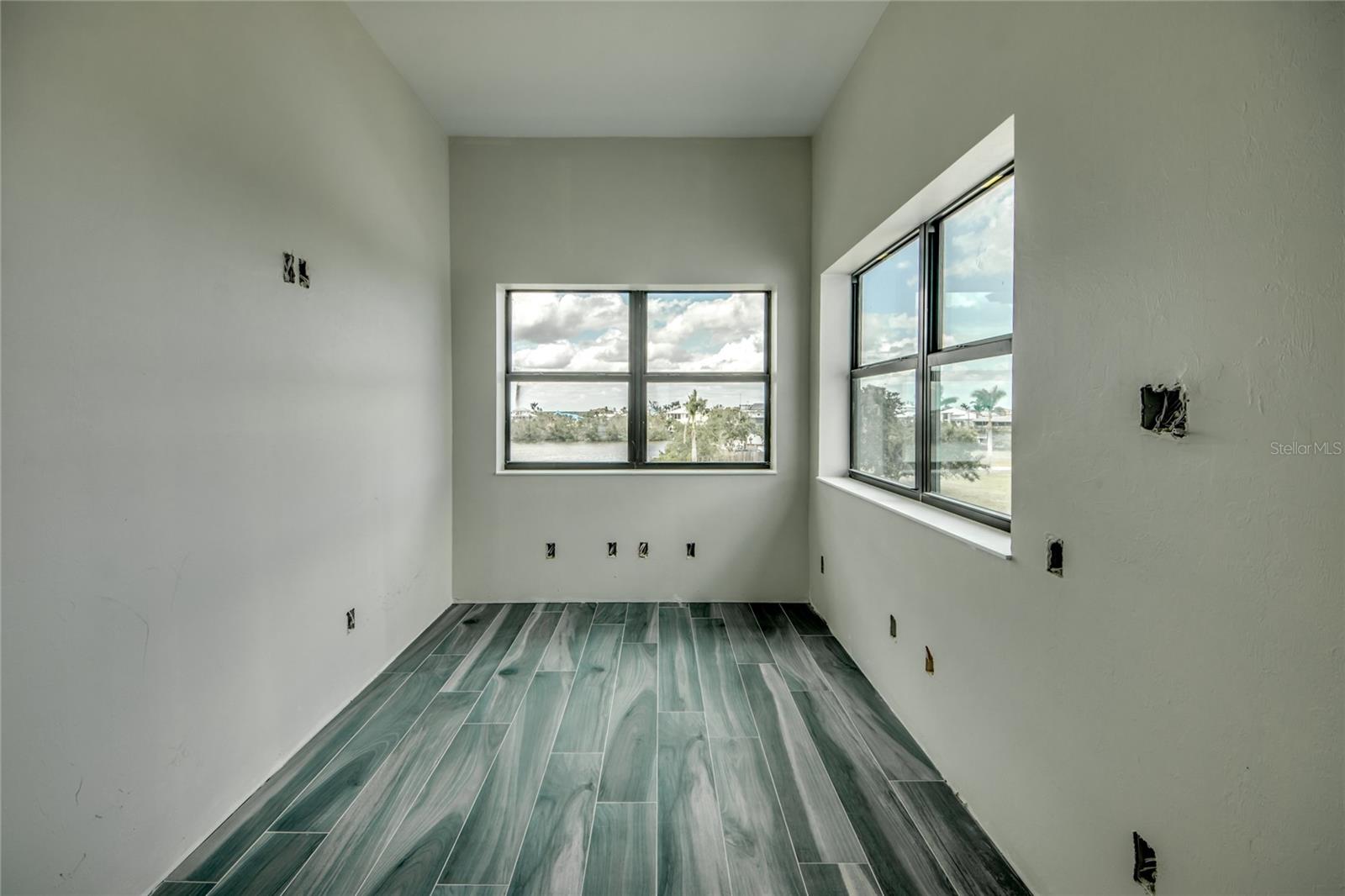 View of the office located and part of the master suite - beautiful ceramic plank style tile with blue hues throughout the entire floor.