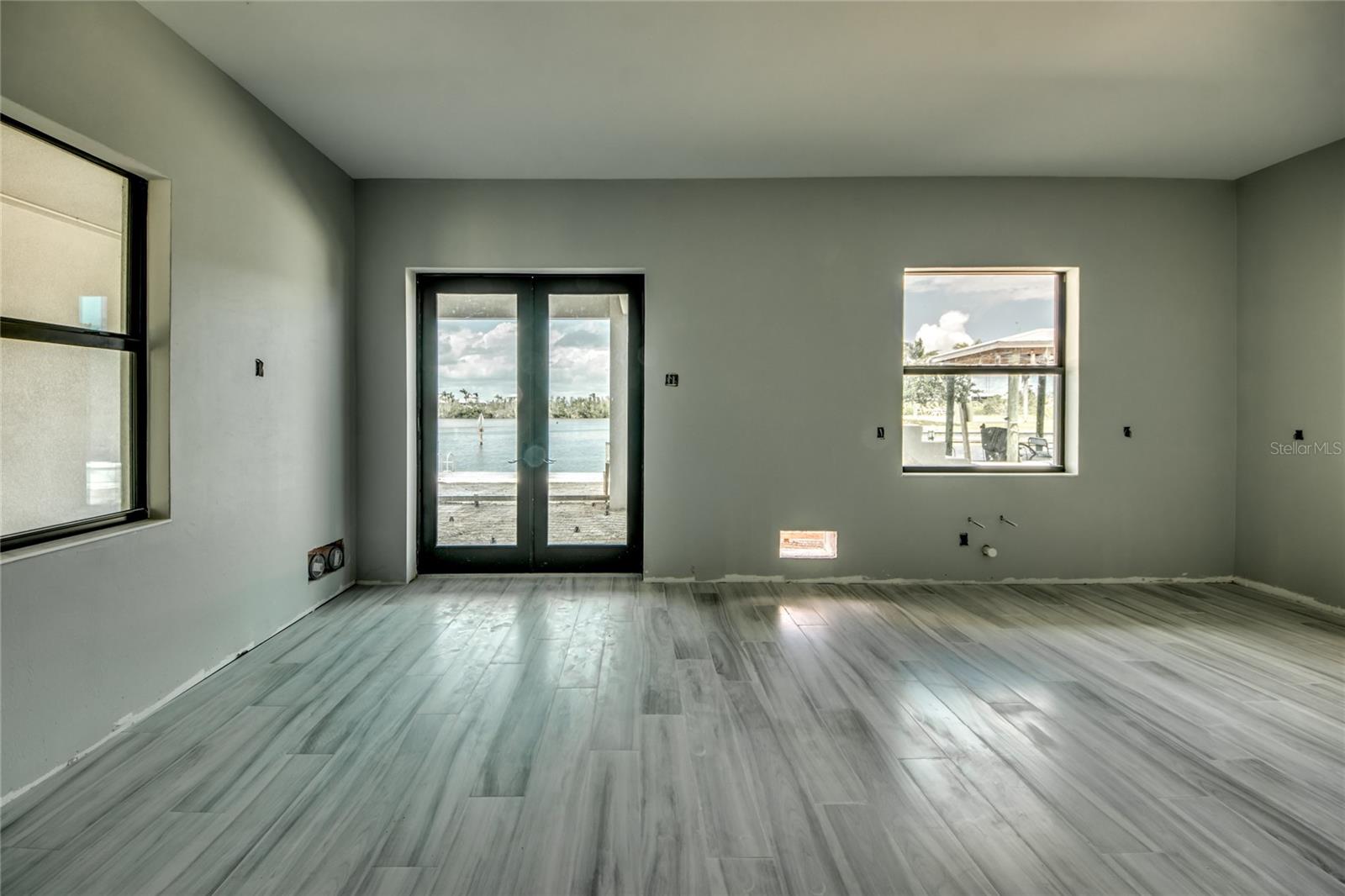 View looking out to the water from the kitchen area.  Very expansive covered patio and easy access out to the boat dock, fish room and garages.  