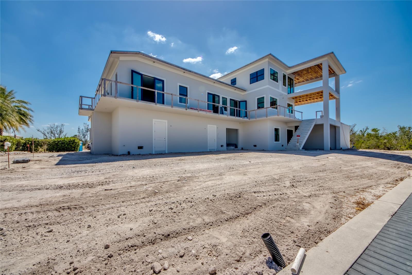 Rear view of the home prior to landscaping.  Newer seawall, boatlifts and docks!