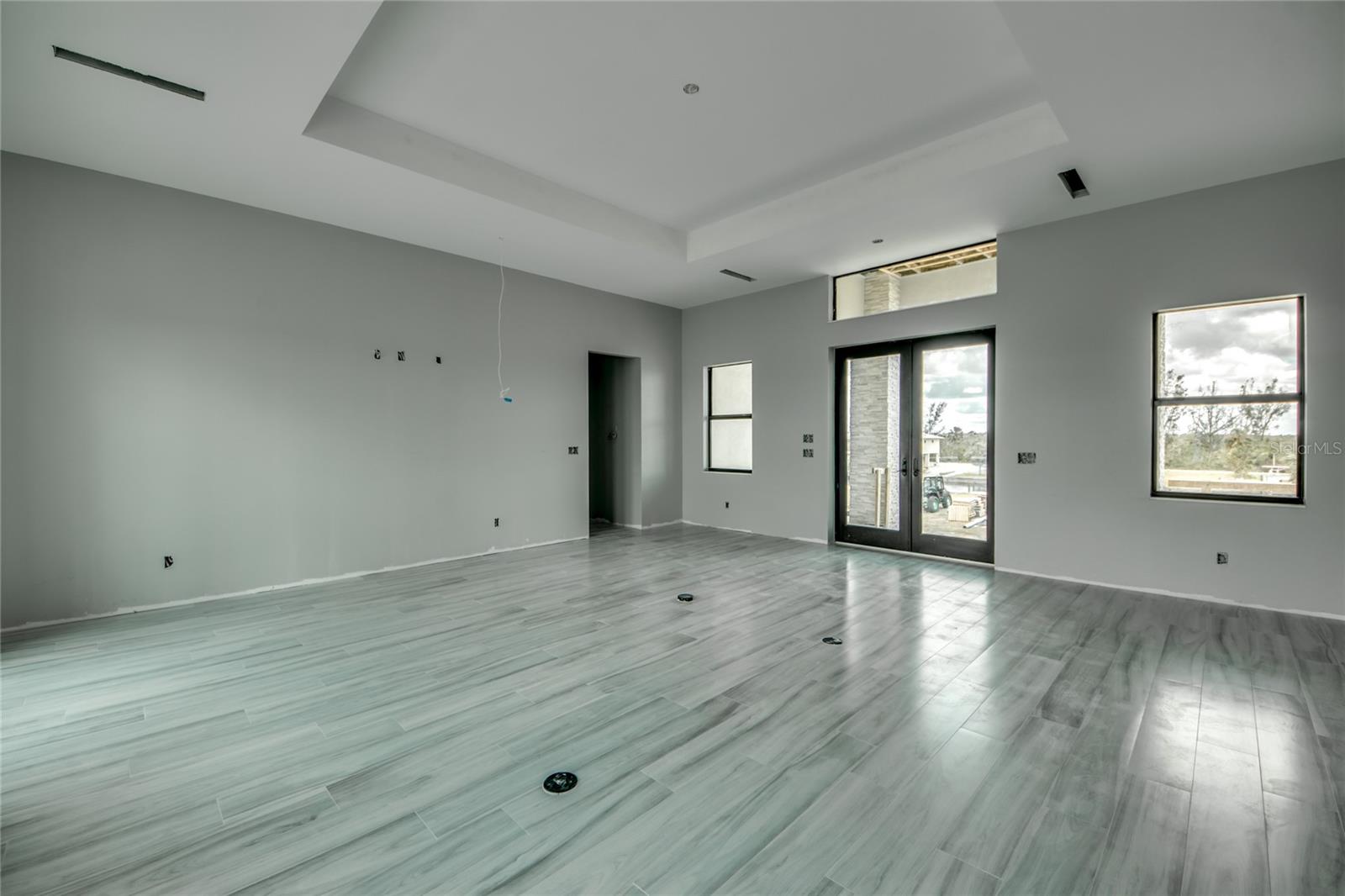 Double door entry into the great room - all PGT Hurricane Windows with additional rolldown hurricane screens on both outdoor patios.  There is a  nice patio on the front of the home as well as a wrap around porch around the length of the entire second floor.