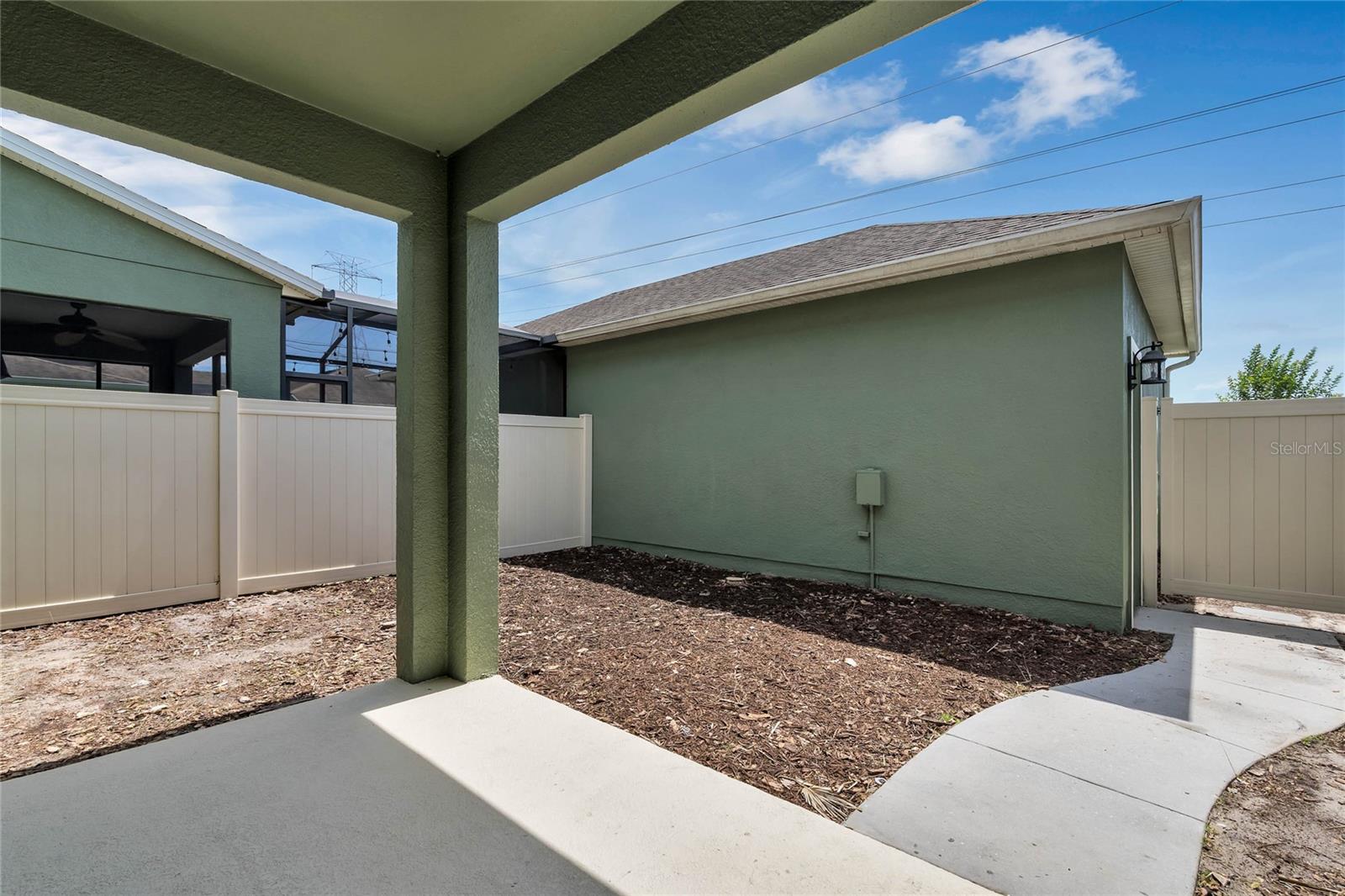 Courtyard and covered patio with two car garage beyond.