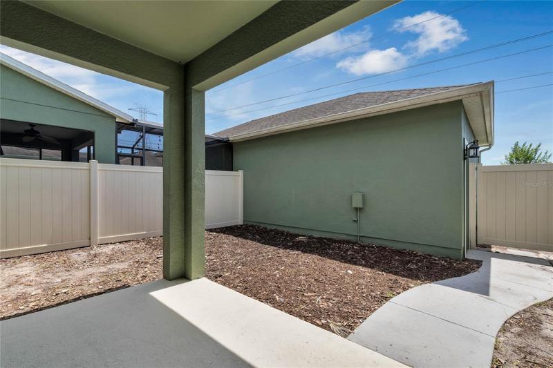 Courtyard and covered patio with two car garage beyond.