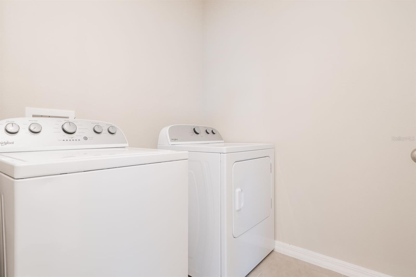 Interior laundry room includes washer/dryer and is tiled