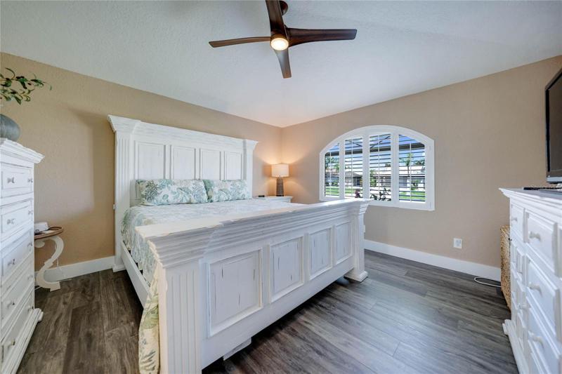 master bedroom has a large window with plantation shutters and nice high ceilings