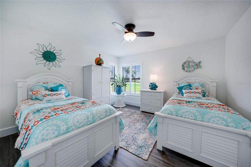 guest bedroom has luxury vinyl plank flooring, a spacious closet and beautiful corner windows overlooking the golf course.  