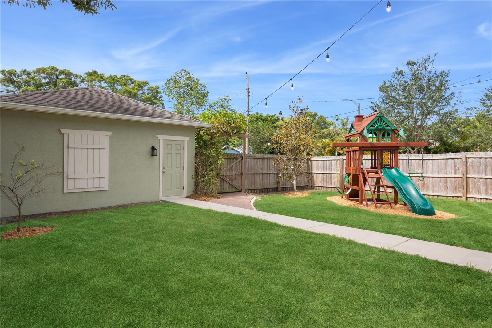 Fenced back yard with access to detached garage and gate leading to parking pad on the alley
