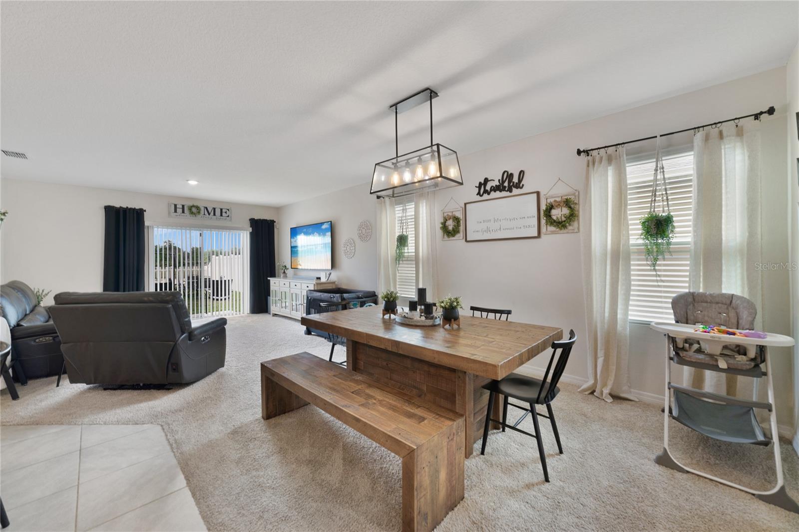 The spacious kitchen, living and dining areas all open with sliding glass door access to a small patio and one of the largest fenced lots in the community!