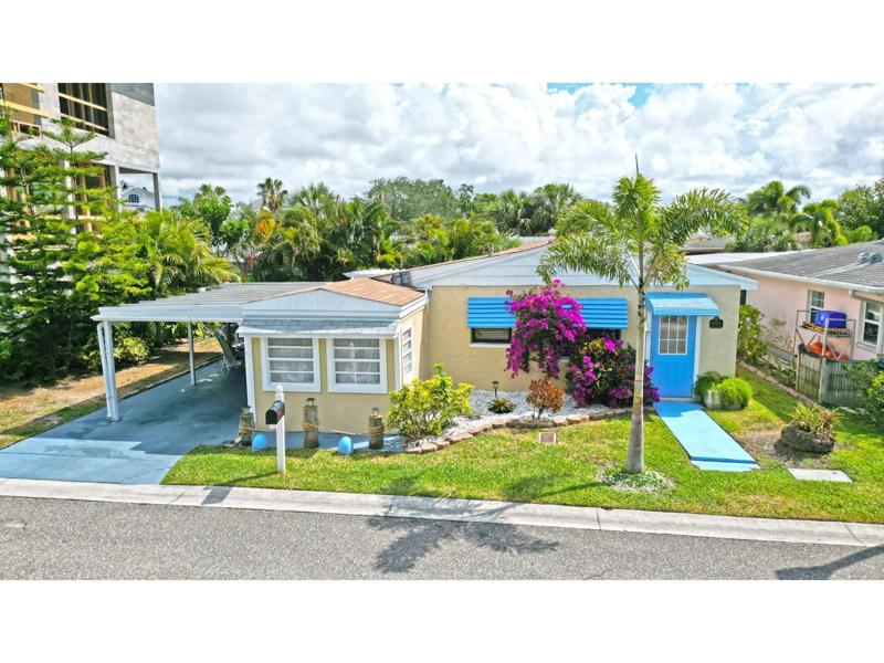 Front view. Mature, Florida landscape. Two outdoor areas, 1 covered/1 with a pergola. Well-maintained home. Move-in ready.  Multi--million dollar home under construction next door.