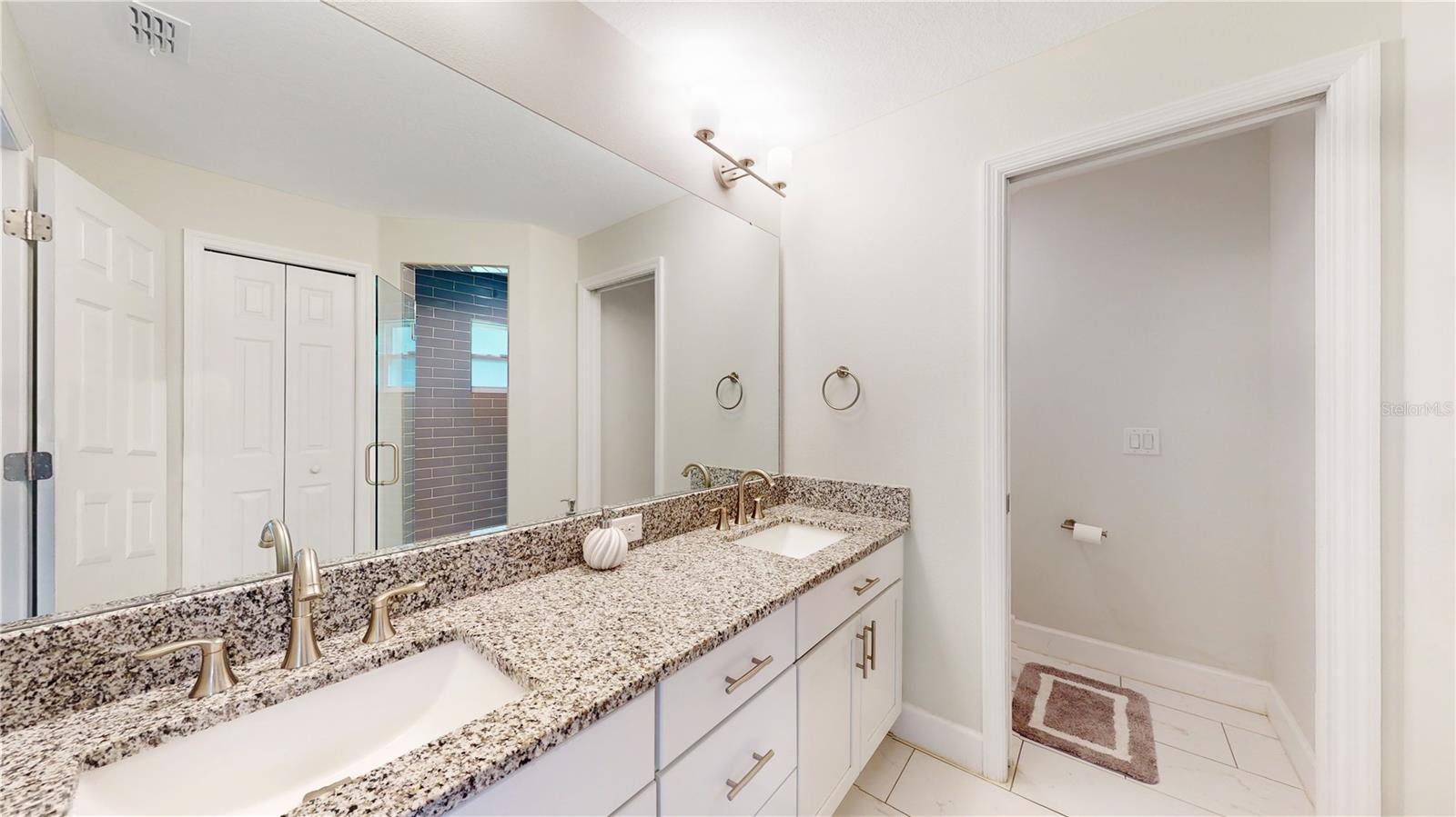 Double sink primary en suite  bathroom. Granite. Mirror goes forever ....