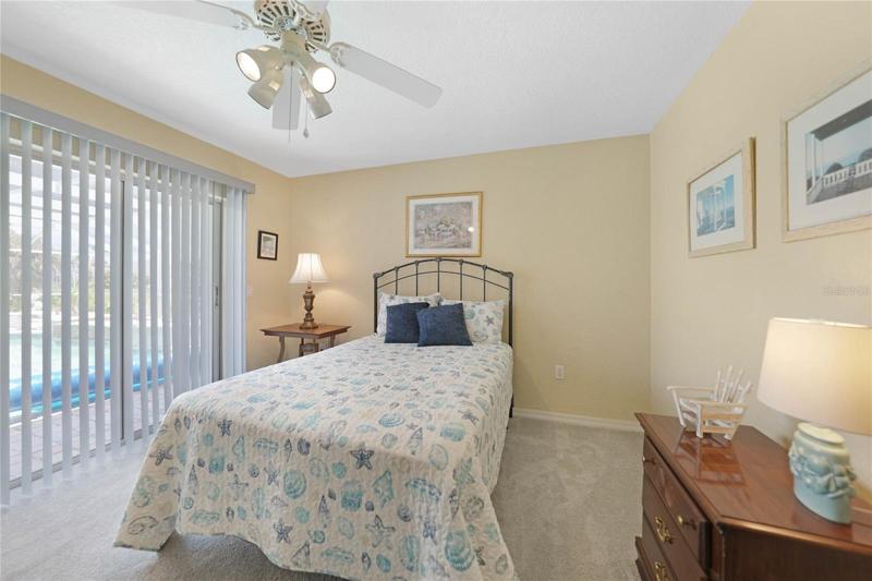 One of two guest bedrooms. This one has view of pool and lanai with easy access from sliders.