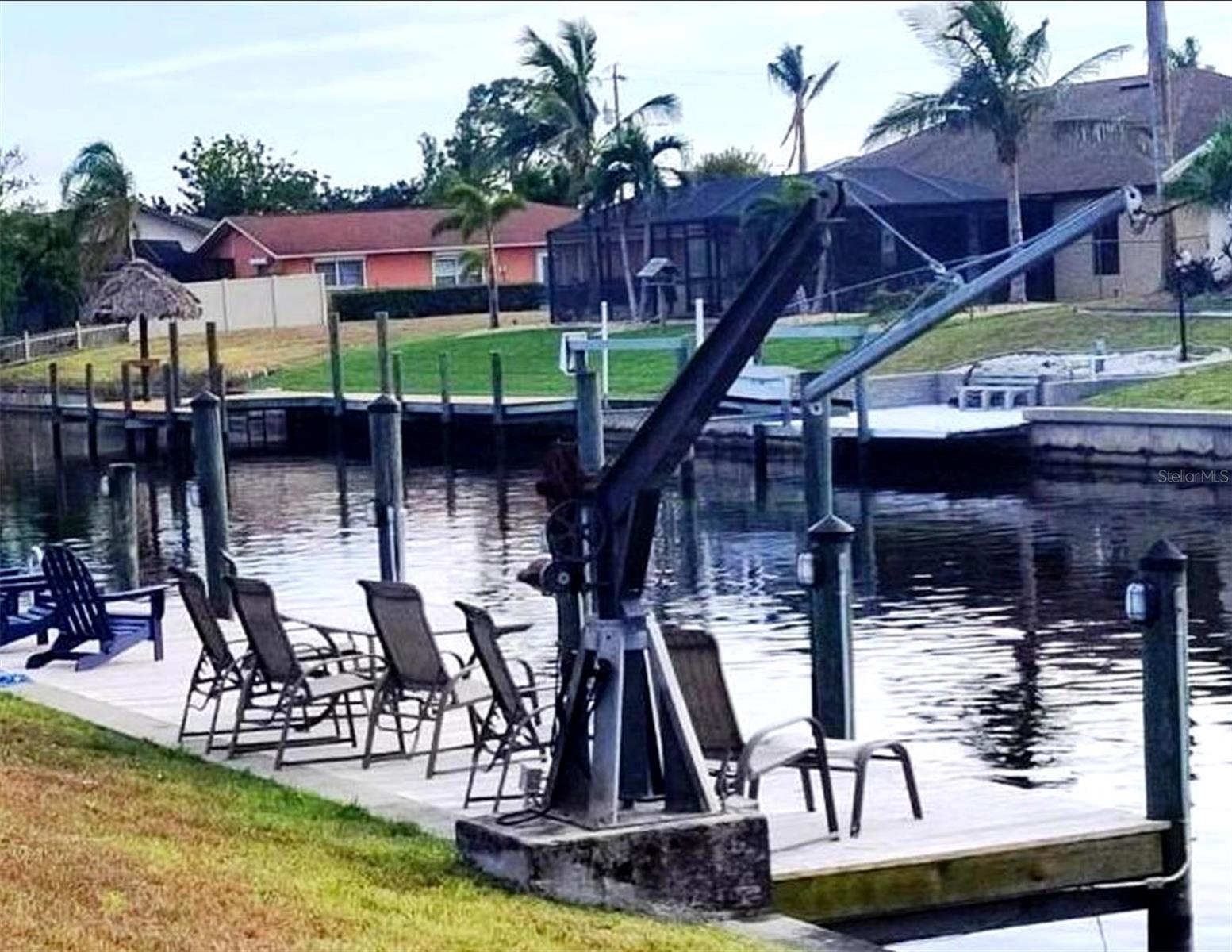 Long enough to make yet another entertaining area with dinner table for 6, Adirondack chairs, lighted pilings, ladder into canal and visiting manatee and dolphin